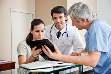 Portrait of mixed race doctor with colleague and female receptionist in hospital reception